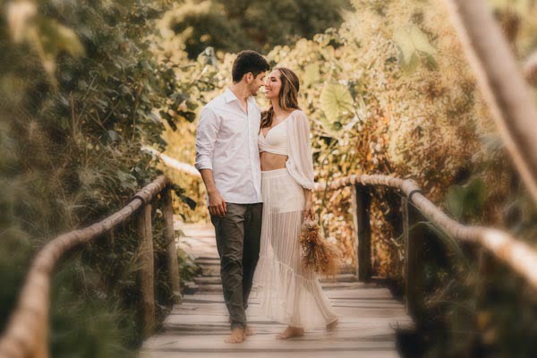 Casal apaixonado caminhando em uma ponte e demonstrando amor