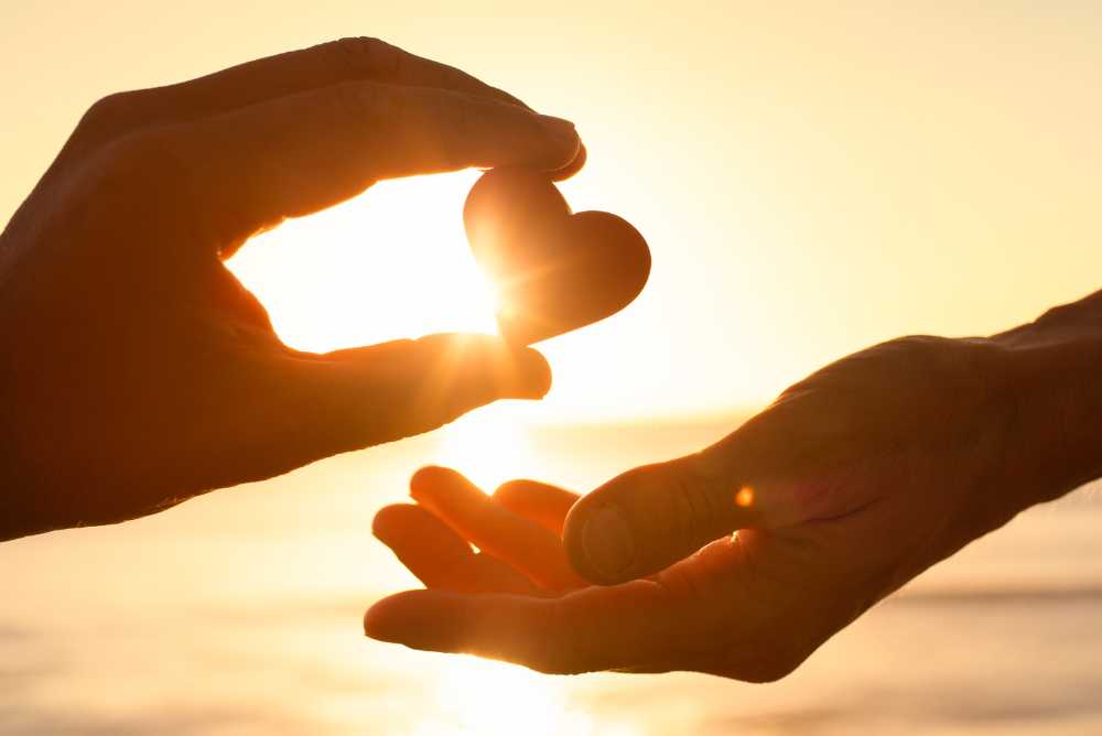 Mão entregando coração para outra mão