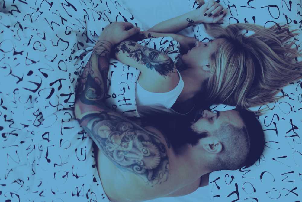 Casal dormindo abraçado na cama