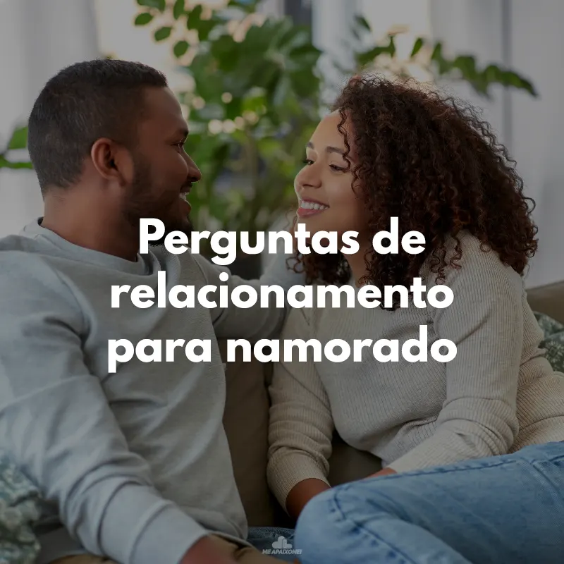 Casal de negros conversando e rindo no sofá