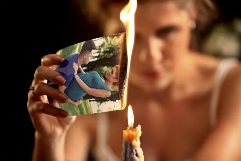 Mulher queimando a fotografia de seu relacionamento que terminou