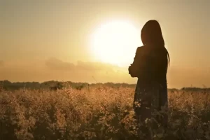 Silhueta de mulher assistindo o por do sol