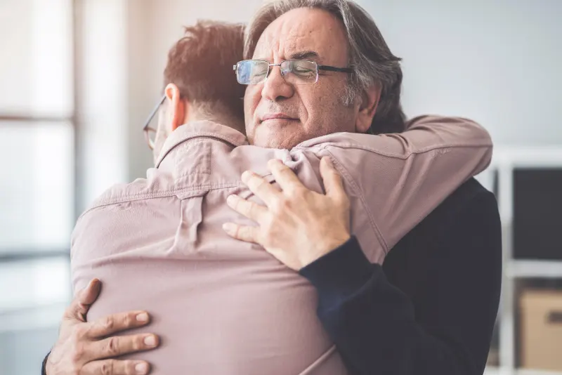 Pai idoso abraçando seu filho