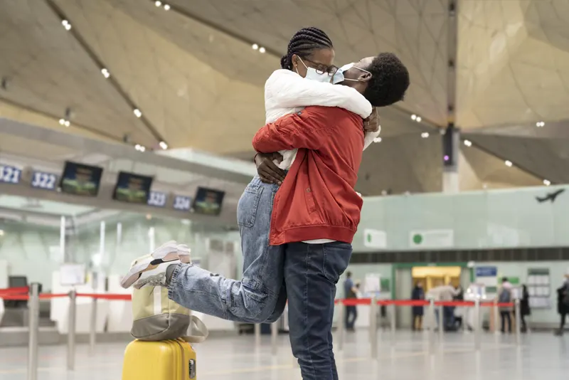 Casal de máscara se encontrando no aeroporto - Como Fazer Um Namoro À Distancia Dar Certo