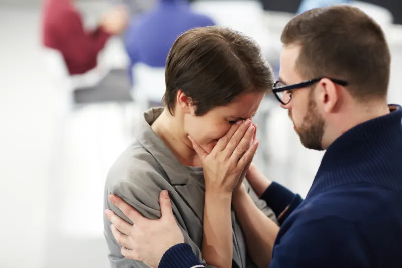 Homem confortando mulher que está chorando - Como superar o término de um relacionamento