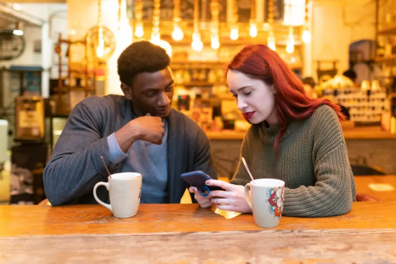 Casal tomando café e mulher mexendo no celular - Lidando com Diferenças de Personalidade e Valores no Namoro