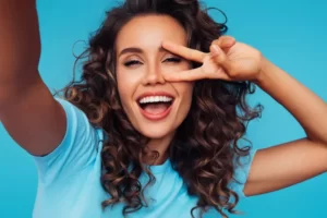 Mulher morena de cabelos cacheados tirando selfie