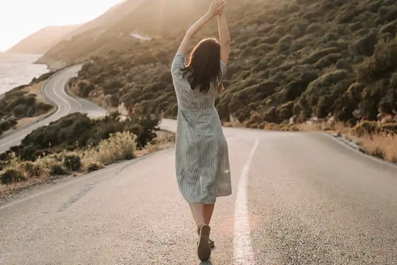 Mulher andando na estrada se sentindo livre - Como Lidar com a Pressão da Sociedade para se Casar e Ter Filhos