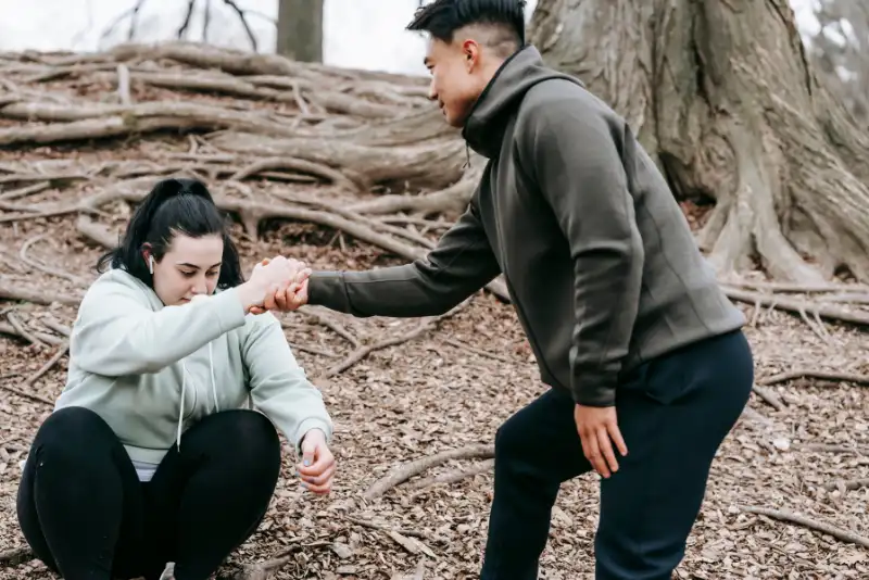 Homem asiático dando a mão mulher a se levantar do chão - Como Fazer Alguém Se Apaixonar Por Você