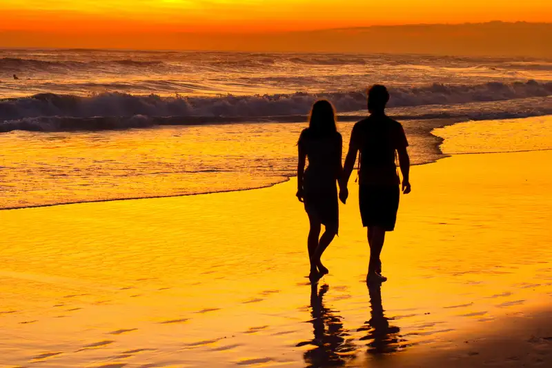 Silhueta de casal caminhando na orla da praia - Como Fazer Alguém Se Apaixonar Por Você