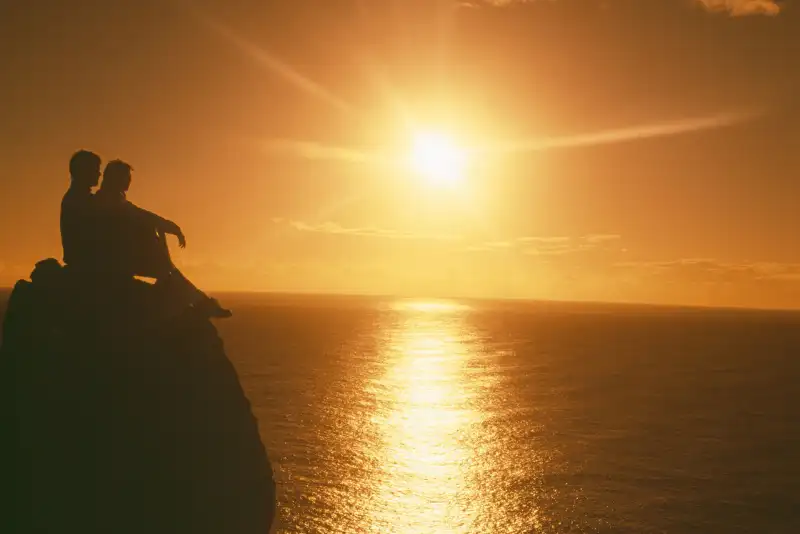 Silhueta de casal assistindo ao por do sol juntos - ideias de atividades divertidas para casais