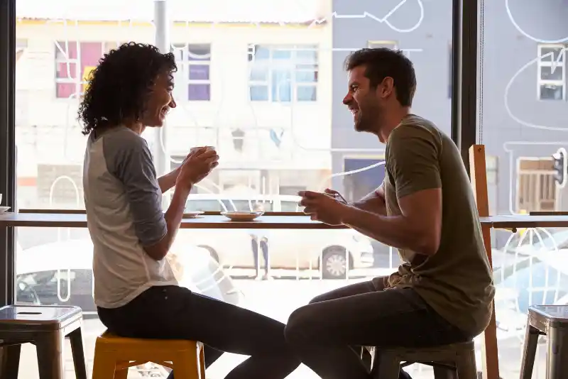 Homem e mulher conversando em um encontro e rindo bastante