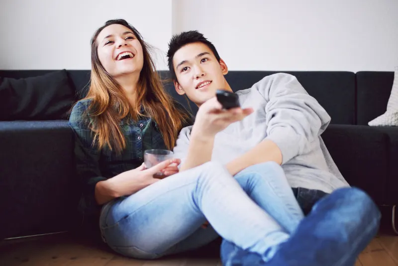 Casal assistindo tv e se divertindo juntos - Perguntas para o crush