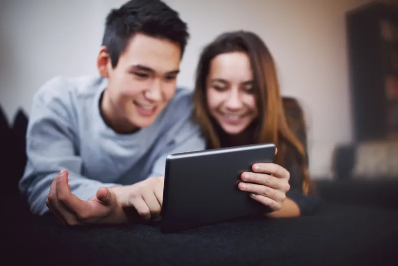 Casal de namorados vendo uma publicação de perguntas para o crush no tablet