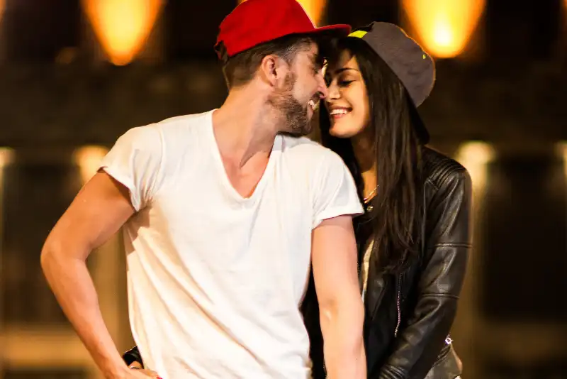 Casal de boné aba reta demonstrando amor e afeto