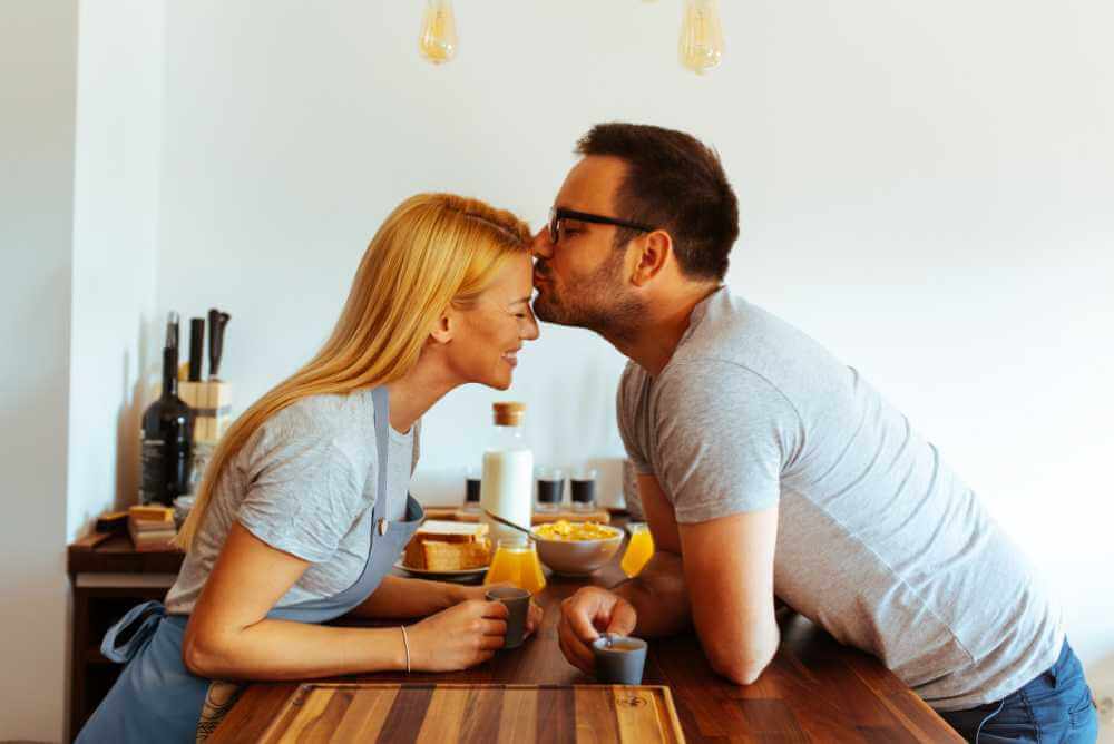 Homem beijando a testa de sua esposa - a idade perfeita para se casar