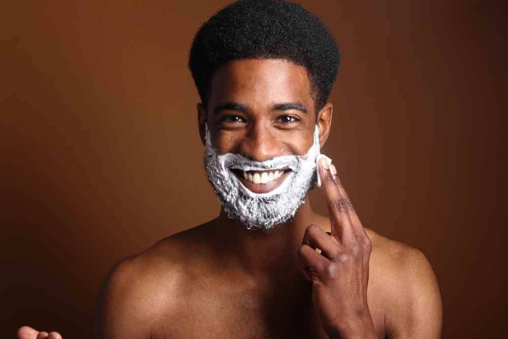 Homem negro se barbeando