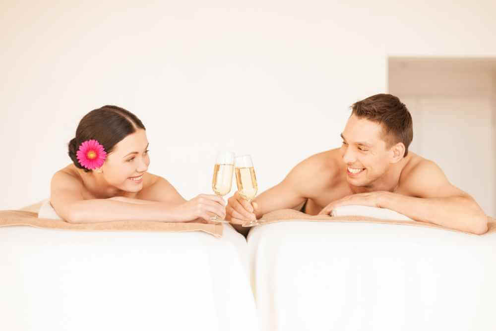 Casal no spa brindando uma taça de champagne