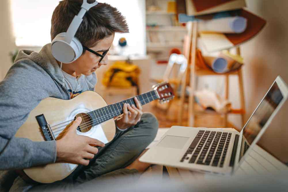 Homem fazendo aula de violão online