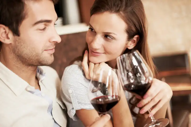 Casal bebendo vinho e trocando olhares - Foto de casal