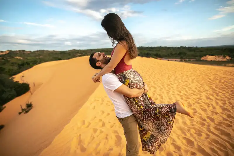 Casal em uma foto romântica nas dunas de areia