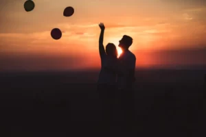 Casal ao por do sol soltando balões