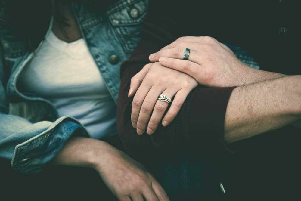 Foto das mãos do casal uma por cima da outra - Necessidades de uma mulher na relação