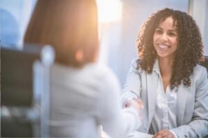 Mulher apertando a mão e fechando negócio com sua cliente