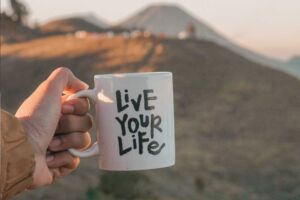 Mulher segurando caneça com frase motivacional