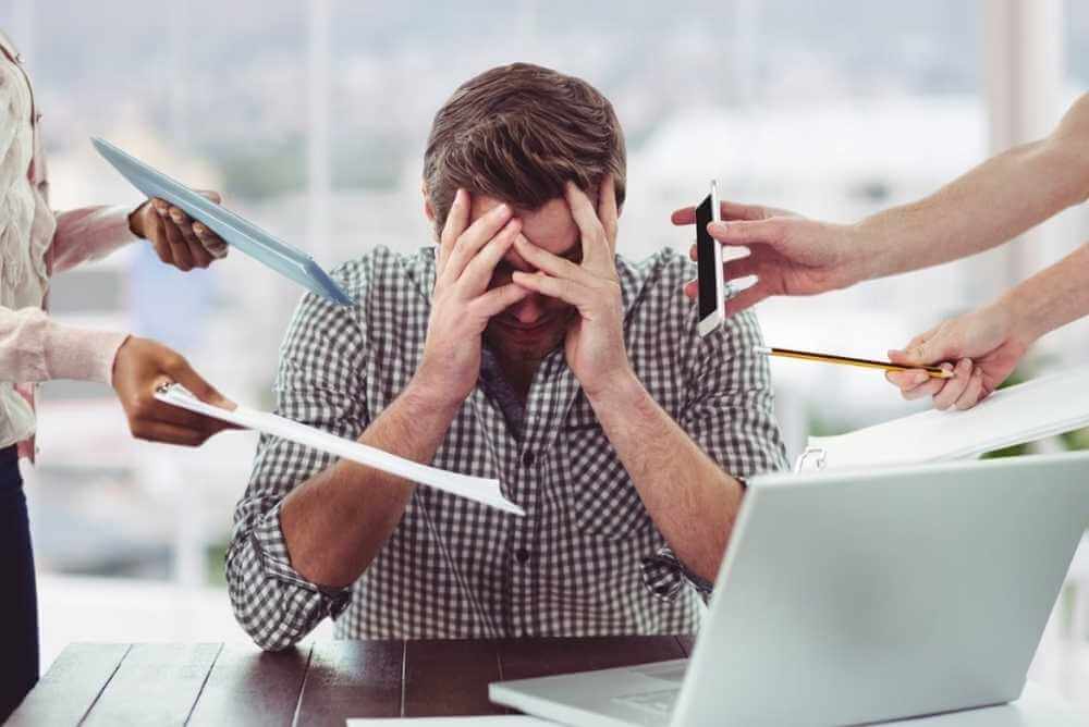Homem com Síndrome de Burnout estressado com as tarefas do trabalho