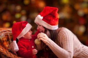 Mãe e filho com gorro de papai noel felizes comemorando o natal