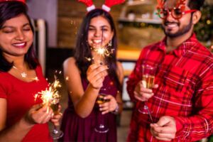 Amigos comemorando o Natal com velas e chapéu de Natal