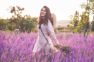 Linda mulher loira andando em um campo de flores rosas