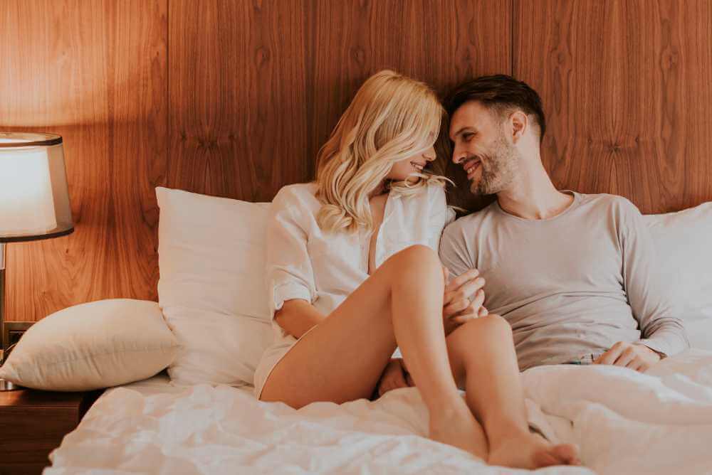 Casal apaixonado de manhã na cama se acariciando