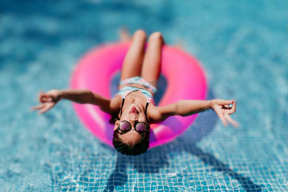 Menina em uma boia rosa na piscina