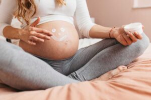 Gravida fazendo de desenho de carinha em sua barriga