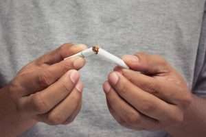 Dia nacional de combate ao fumo: Imagem de homem quebrando um cigarro ao meio