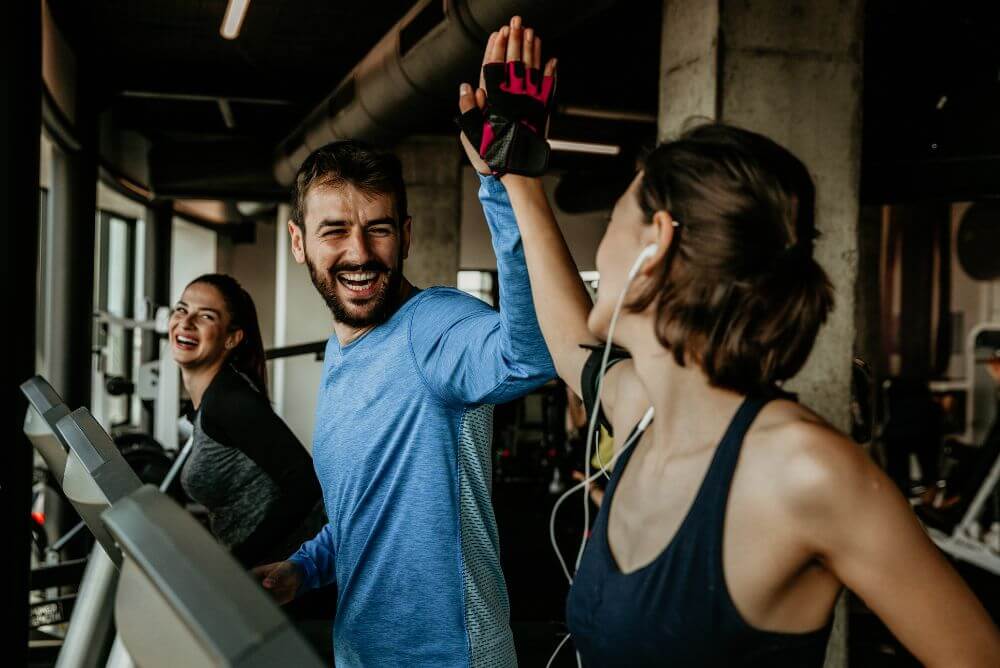 Frase de companheirismo - Mulher cumprimentando homem na academia